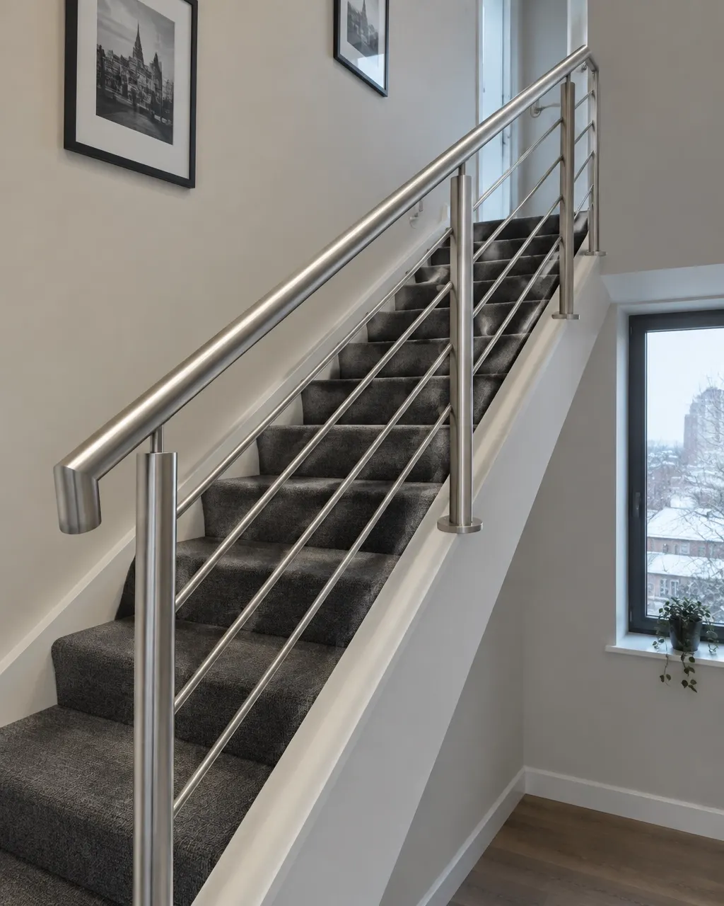 Brushed steel stair handrail and balustrade fitted at the correct height to an indoor staircase