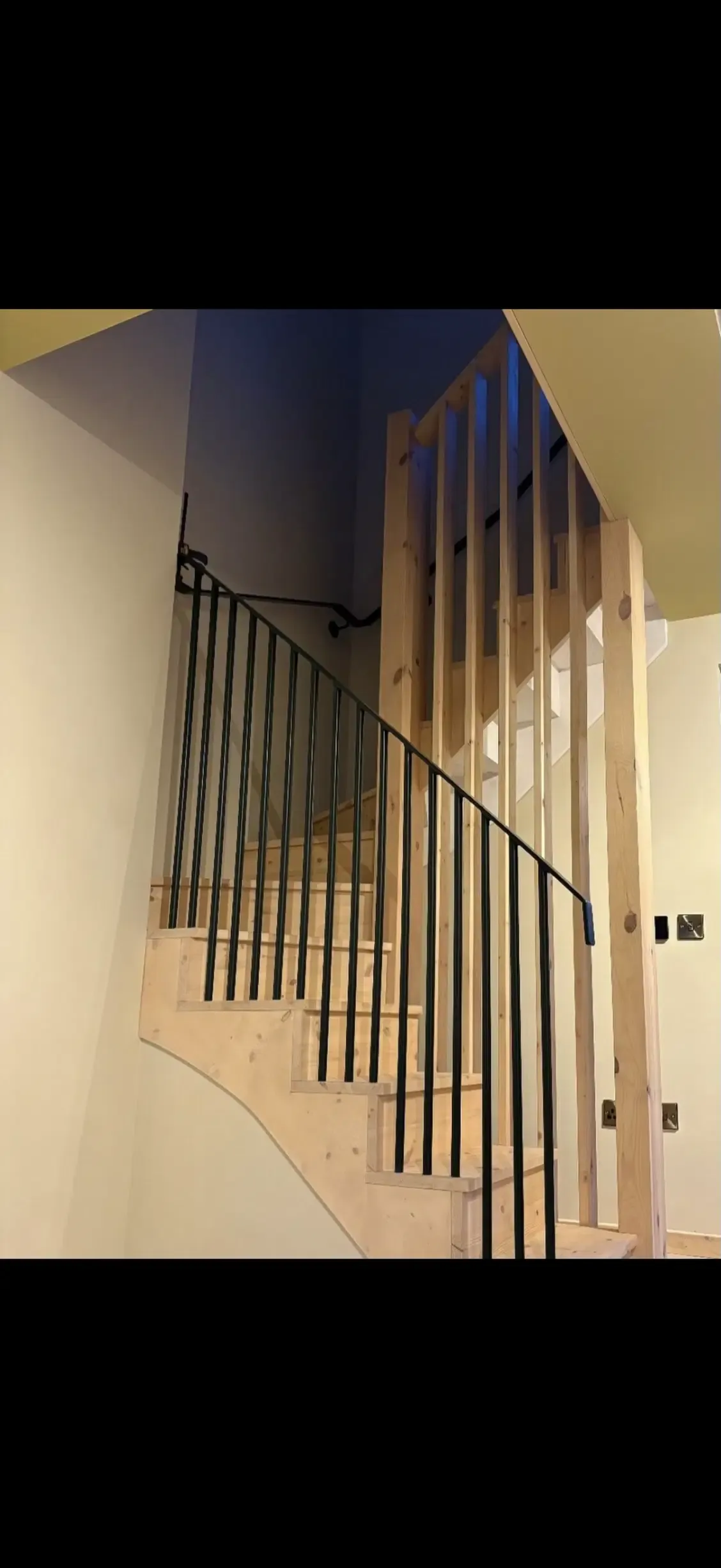 Dark steel railings installed beside front steps during house renovation work